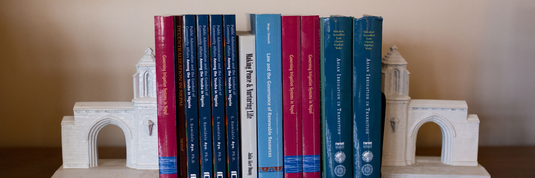 A stack of attractive red and blue books supported by cast bookends of IU's Sample Gates