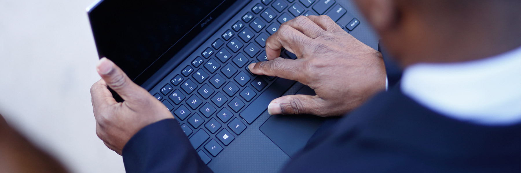 A closeup of hands typing on a computer. 